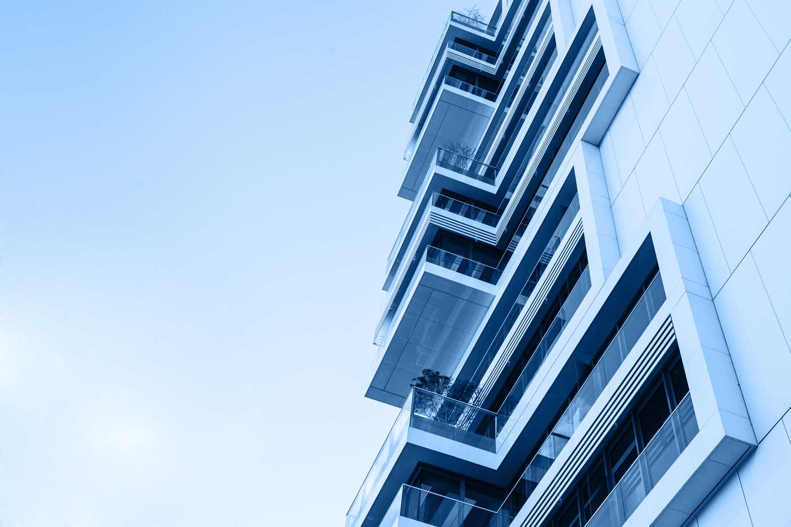 The corner of the building with many windows in trendy classic blue color.