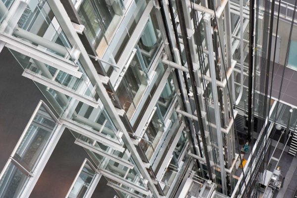 Looking down in an open steel lift shaft in a modern building