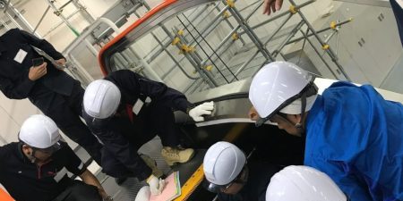 Engineers from Fujitec's global companies confirm escalator operation using a multilingual manual; image courtesy of Fujitec. 