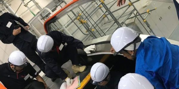 Engineers from Fujitec's global companies confirm escalator operation using a multilingual manual; image courtesy of Fujitec. 