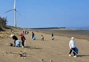 Fujitec employees pick up trash on a beach in Taiwan; image courtesy of Fujitec.