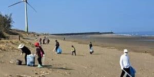 Fujitec employees pick up trash on a beach in Taiwan; image courtesy of Fujitec.