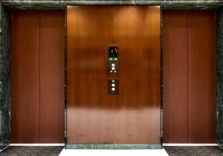 Front of Two close elevators in old retro style Hotel