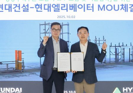 Cho Jae-cheon, CEO of Hyundai Elevator, left, and Yoon Jeong-il, head of Hyundai E&C's purchasing division, sign an MoU at Hyundai E&C's headquarters in Jongno-gu, Seoul; image courtesy of Hyundai Elevator