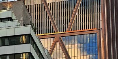 The reflective glass and bronze-hued cladding covers more of the skyscraper; photo by Michael Young for New York YIMBY. 