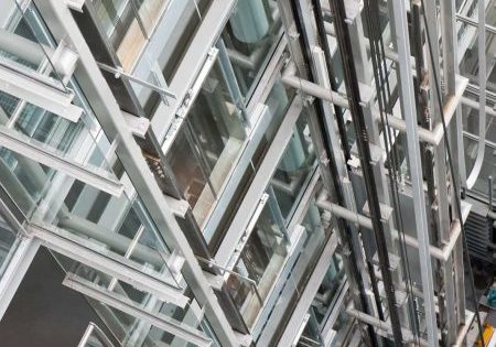 Looking down in an open steel lift shaft in a modern building