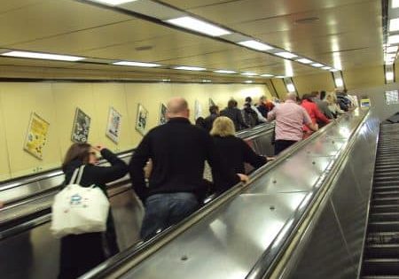 Escalators at the entrance to the busy Moorfields station; photo by ReptOn1x for Wikipedia