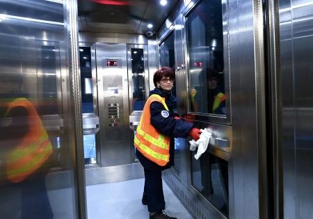 A worker polishes the handrail inside one of the new elevators; image courtesy of MTA