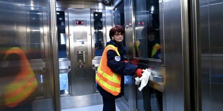 A worker polishes the handrail inside one of the new elevators; image courtesy of MTA