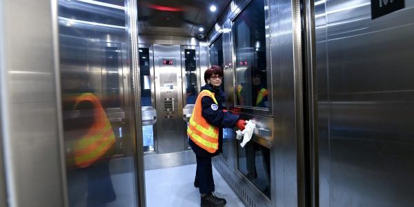 A worker polishes the handrail inside one of the new elevators; image courtesy of MTA