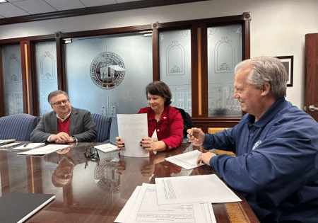 (l-r) Philip Grone, Amy Blankenbiller and Frank Christensen sign the MEL; photo courtesy of NEII.