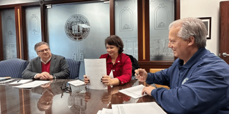 (l-r) Philip Grone, Amy Blankenbiller and Frank Christensen sign the MEL; photo courtesy of NEII.