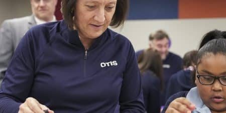 Otis President and CEO Judy Marks works with a student as part of the Boys & Girls Clubs program in Hartford, Connecticut; image courtesy of Otis. 