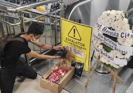 A commuter kneels before the broken Bekasi Station escalator; image courtesy of TEMPO.CO. 