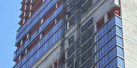 Construction hoists traverse the exterior of 98 Dekalb Avenue; photo by Michael Young for New York YIMBY. 