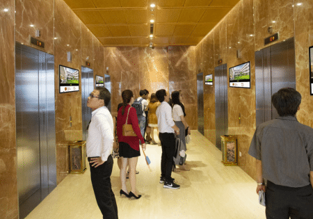 Watching advertisements while waiting for the elevator is common among many office workers and residents; image courtesy of Chicilon.