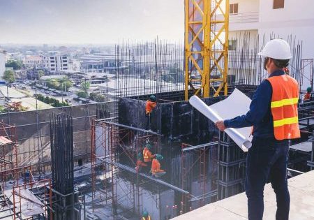 Smart civil architect engineer inspecting and working outdoors building side with blueprints. engineering and architecture concept. VT Trends