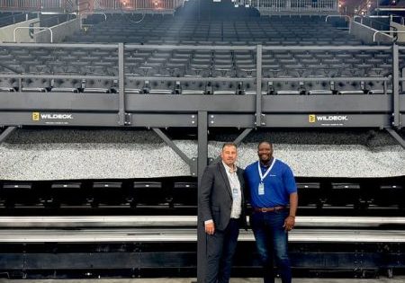 Wildeck President Dan Lorenz (left) and VP of Sales and Marketing Demetrius Lindsey (right) in front of a mezzanine installed for the event; image via Material Handling Wholesaler