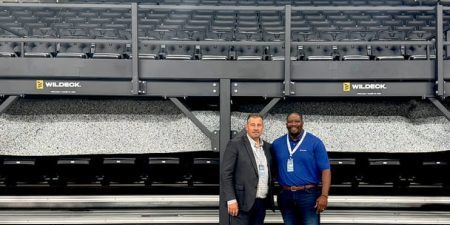 Wildeck President Dan Lorenz (left) and VP of Sales and Marketing Demetrius Lindsey (right) in front of a mezzanine installed for the event; image via Material Handling Wholesaler