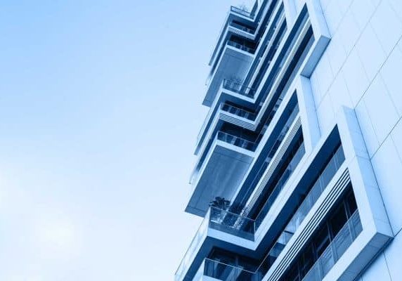 The corner of the building with many windows in trendy classic blue color.