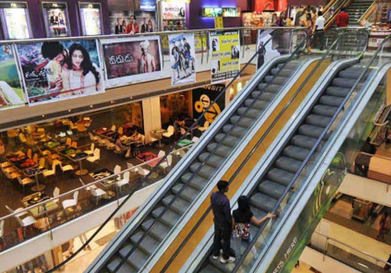 Shoppers ride escalators at a mall in Mumbai; image from The Hindu.